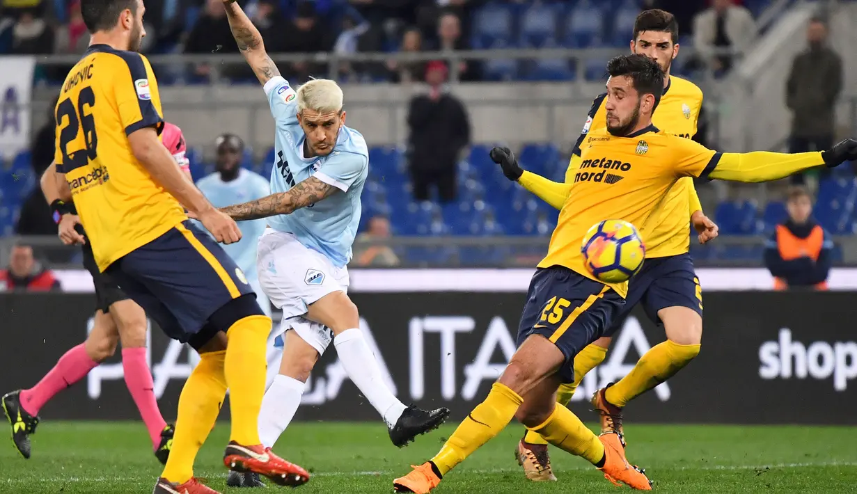 Pemain Lazio, Luis Alberto (2kiri) melepaskan tembakan melewati adangan dua pemain Hellas Verona pada lanjutan Serie A di di Olympic stadium, Roma, (19/2/2018). Lazio menang 2-0. (AFP/Alberto Pizzoli)