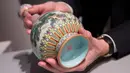Vas China antik berusia ratusan tahun diperlihatkan di rumah lelang Sotheby, Paris, Selasa (22/5). Vas yang diyakini berasal dari masa Dinasti Qing di abad ke-18 itu ditafsir bernilai lebih dari 500.000 euro (sekitar Rp 8,3 miliar). (AFP/Thomas SAMSON)