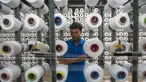 Seorang pekerja mengatur gulungan benang untuk alat tenun di pabrik Trisula Textile Industries di Cimahi, Jawa Barat pada 15 April 2025. (TIMUR MATAHARI/AFP)