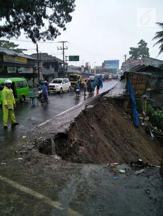 Petugas kepolisian berjaga di dekat lokasi longsor yang terjadi di kawasan Puncak Bogor, Jawa Barat (5/2). Tanah longsor menutup seluruh badan jalan hingga tak bisa dilintasi kendaraan. (Foto: Lantas Bogor)