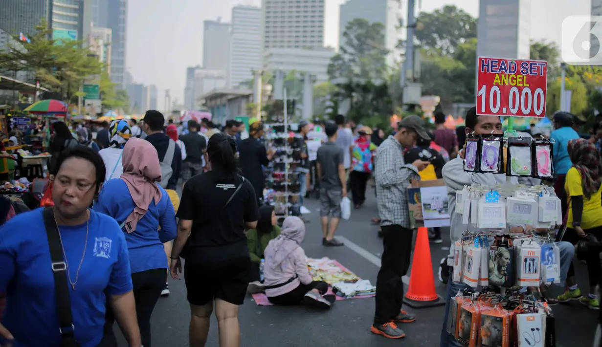 Pedagang kaki lima (PKL) berjualan di jalan saat car free day (CFD) di kawasan Bundaran HI, Jakarta, Minggu (6/10/2019). Banyaknya PKL nakal yang berjualan tidak pada tempatnya menyebabkan olahraga warga terganggu. (Liputan6.com/Faizal Fanani)