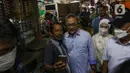 Menteri Perdagangan Zulkifli Hasan (tengah) berfoto dengan warga saat meninjau harga bahan pokok di Pasar Cibubur, Jakarta, Kamis (16/6/2022). Kunjungan tersebut dilakukan untuk melihat dan memantau langsung harga bahan pokok guna memastikan harga stabil menjelang Hari Raya Idul Adha 1443 Hijriah. (Liputan6.com/Herman Zakharia)
