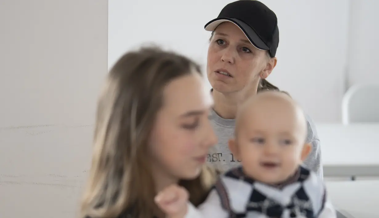 Kateryna Kyreieva (latar belakang) ibu dari Vlada Yushchenko, seorang pengungsi Ukraina berusia 19 tahun berbicara, saat wawancara dengan The Associated Press di Brasov, Rumania pada 2 Februari 2023. Sekarang dia berada di Rumania, salah satu dari jutaan orang Ukraina yang terpaksa melarikan diri dari invasi Rusia. (AP Photo/Vadim Ghirda)