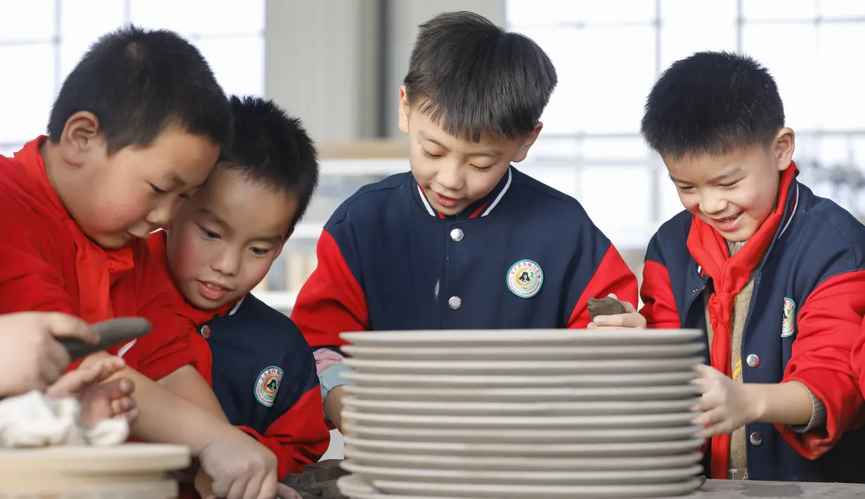 Sejumlah siswa sekolah dasar mencoba membuat porselen di bengkel kerja porselen Ru di Baofeng, Provinsi Henan, China, 15 November 2020. Baofeng dikenal sebagai produsen porselen Ru, satu dari lima porselen yang tersohor selama era Dinasti Song (960-1279) pada zaman China kuno. (Xinhua/He Wuchang)