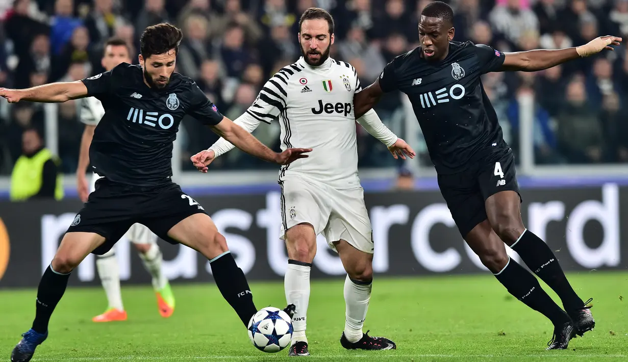 Penyerang Juventus, Gonzalo Higuain (tengah) berusaha membawa bola dari kawalan dua pemain Porto pada leg kedua 16 besar Liga Champions di Stadion Juventus, Turin, Italia, (15/3). Juventus menang atas Porto dengan skor 1-0. (AFP Photo/Giuseppe Cacace)