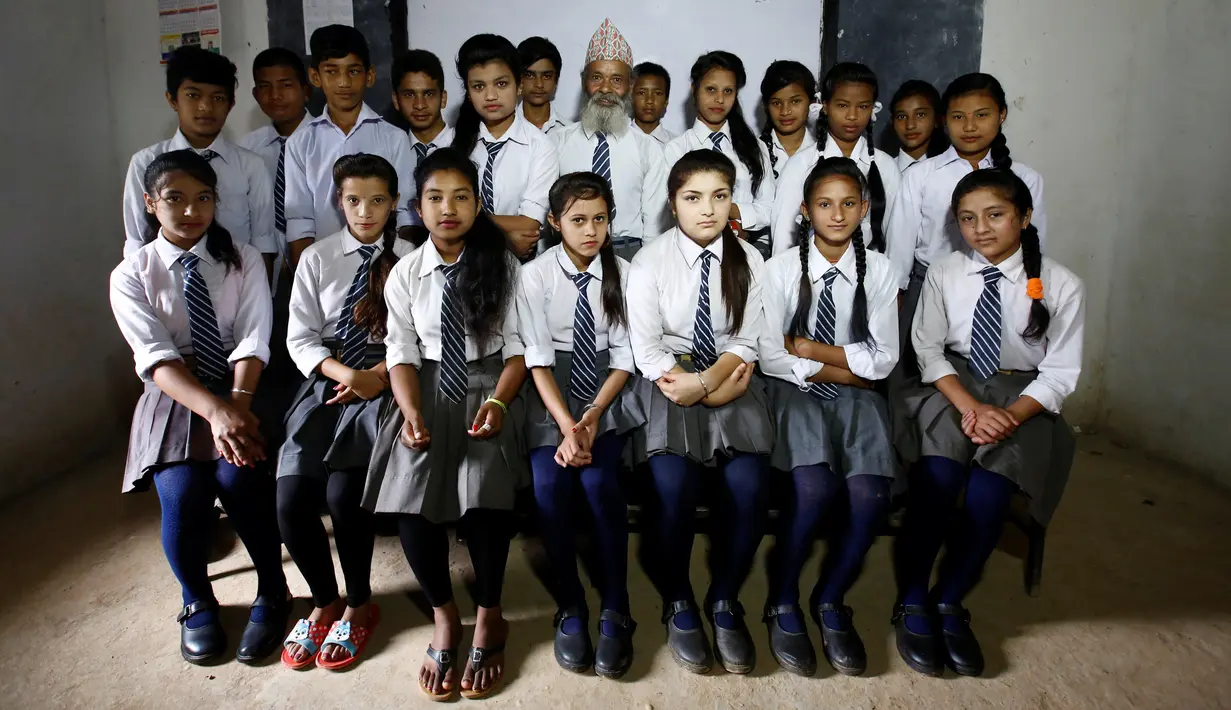 Durga Kami berfoto bersama siswa lainnya di ruang kelas di SMA Shree Kala Bhairab di Syangja, Nepal, 5 Juni 2016. Siapa sangka kakek berusia 68 tahun itu ternyata seorang siswa kelas X. (REUTERS/Navesh Chitrakar)