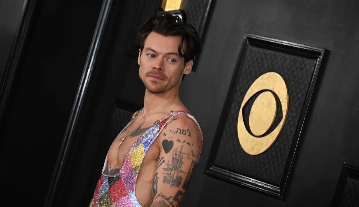 Penyanyi-penulis lagu Inggris, Harry Styles tiba untuk ajang Grammy Awards 2023 di Crypto.com Arena, Los Angeles, AS, Minggu Malam (6/2/2023) waktu setempat. Harry Styles tampil unik dengan busana motif ketupat warna-warni dari Egonlab x Swarovski. (Photo by Robyn BECK / AFP)