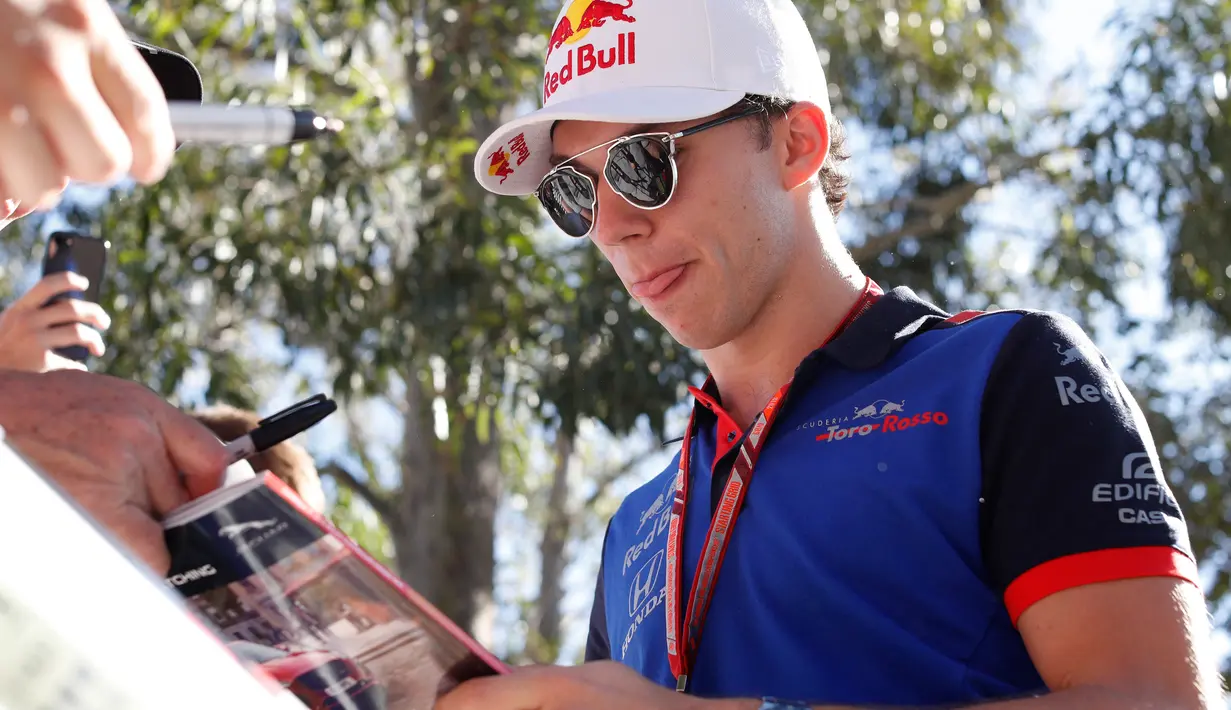 Pembalap tim Toro Rosso, Pierre Gasly memberikan tanda tangan kepada fans sesaat sebelum latihan bebas Formula 1 (F1) GP Australia di Melbourne, Jumat (23/3). Balapan F1 GP Australia 2018 sendiri akan bergulir pada Minggu, 25 Maret besok (AP/Rick Rycroft)