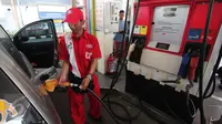  Petugas mengisi bahan bakar jenis Premium di SPBU Cikini, Jakarta, Kamis (24/12). Jelang awal tahun 2016, Pemerintah memutuskan menurunkan harga Bahan Bakar Minyak (BBM) jenis Premium dan Solar. (Liputan6.com/Angga Yuniar)