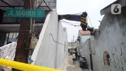 Truk crane yang terguling dan menimpa rumah warga di di Jalan Mawar, Perumnas Depok Jaya, Depok, Jawa Barat, Jumat (15/10/2021). Truk crane di kawasan Proyek PDAM terguling dan menimpa rumah menyebabkan tiga warga mengalami luka serius. (merdeka.com/Arie Basuki)