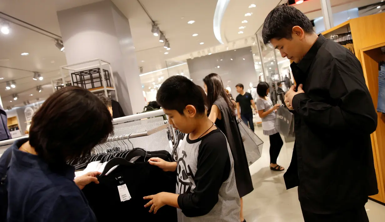 . Orang-orang berbelanja pakaian hitam atau putih untuk menghadiri penghormatan terakhir atas meninggalnya Raja Thailand Bhumibol Adulyadej di sebuah mall Bangkok, Thailand (15/10). (REUTERS / Edgar Su)