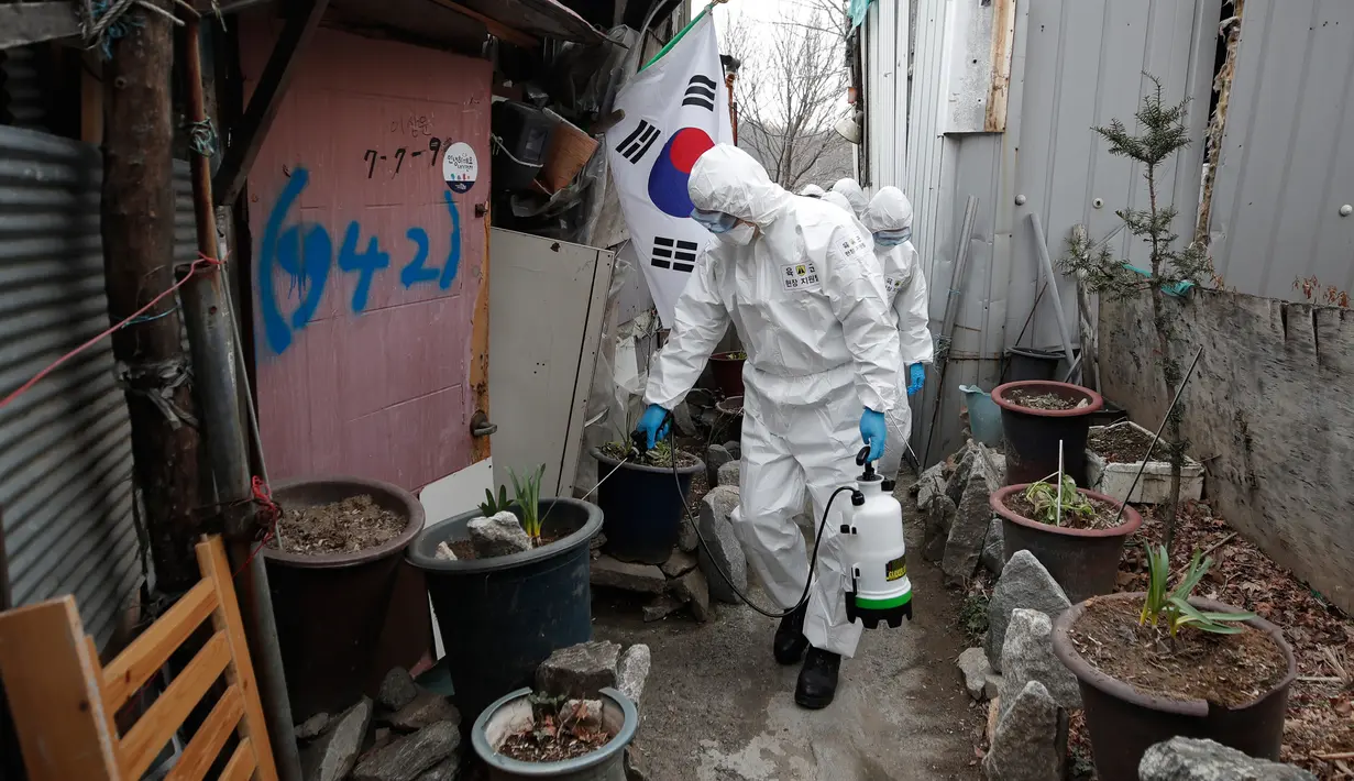 Tentara Korea Selatan yang mengenakan pakaian pelindung menyemprotkan desinfektan di gang-gang permukiman di Seoul, Selasa (3/3/2020). Seoul mengerahkan tentara untuk menyemprotkan disinfektan di jalan dan gang-gang untuk mencegah penyebaran virus corona COVID-19. (AP Photo/Lee Jin-man)