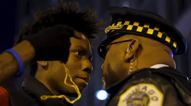 Massa bersitegang dengan polisi saat aksi protes di Chicago, Illinois, Rabu (25/11). Ketegangan rasial memanas setelah rilisnya video seorang polisi kulit putih menembak remaja kulit hitam, Laquan McDonald (17) pada Oktober 2014. (REUTERS/Andrew Nelles)