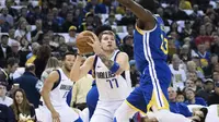 Luka Doncic (baju putih) mencoba mengecoh pemain Warriors Draymond Green pada lanjutan NBA (AP)