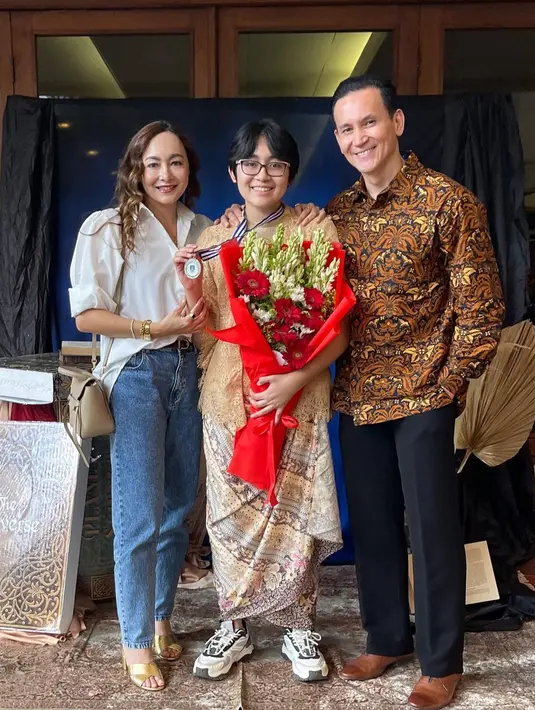 Hadiri wisuda anak pertama, Rezer Dewi tampil chic dengan padu padan oversized shirt warna putih dan denim pants. [@rezerdewi]