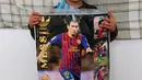 Seorang anak laki-laki Afghanistan, Murtaza Ahmadi, memegang poster Lionel Messi di kabupaten Jaghori, provinsi Ghazni, 29 Januari 2016. Murtaza adalah bocah yang sempat membuat heboh dunia maya karena memakai jersey kantong kresek Messi. (STR/AFP)