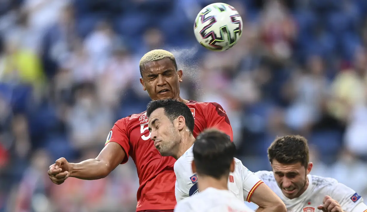 Bek timnas Swiss, Manuel Akanji menyundul bola saat kontra Spanyol pada perempat final Euro 2020 di Krestovsky Stadium, Saint Petersburg, Sabtu (3/7/2021) dini hari WIB.  Spanyol menyingkirkan Swiss 3-1 (1-1) melalui adu penalti. (Kirill Kudryavtsev, Pool via AP)