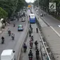 Pengendara motor melaju di belakang bus Transjakarta di kawasan Pasar Rumput, Jakarta, Rabu (20/2). Kamera pengawas atau CCTV akan dipasang di setiap halte Transjakarta yang terintegrasi dengan Ditlantas Polda Metro Jaya. (Liputan6.com/Immanuel Antonius)