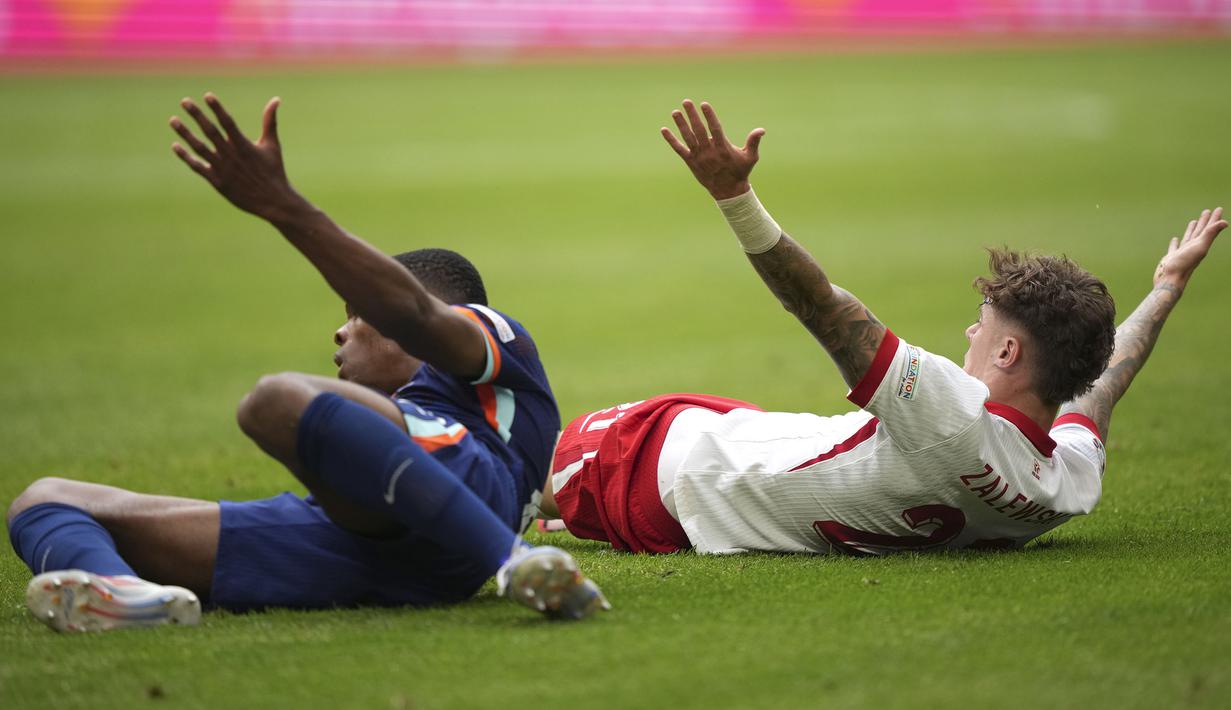 Bek Timnas Belanda, Denzel Dumfries (kiri) dan gelandang Timnas Polandia, Nicola Zalewski saling bereaksi setelah keduanya terjatuh usai perebutan bola pada laga Grup D Euro 2024 di Volksparkstadion, Hamburg, Jerman, Minggu (16/6/2024). (AP Photo/Ebrahim Noroozi)