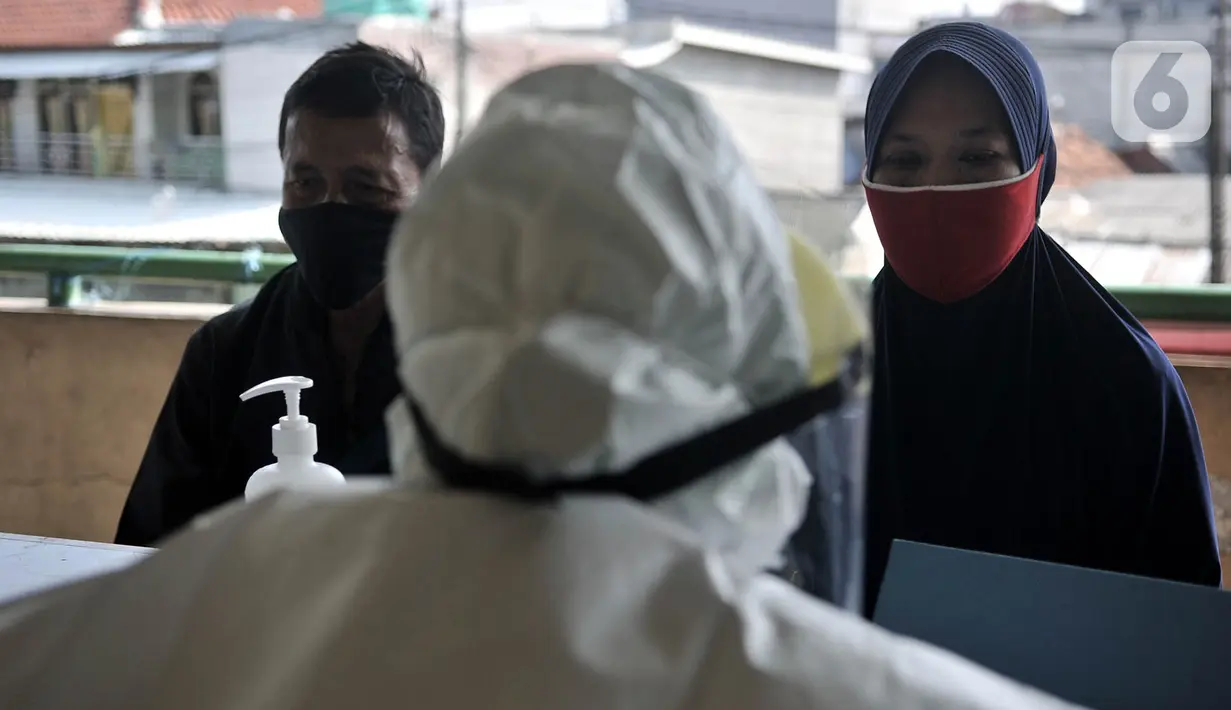 Pedagang menjalani rangkaian pemeriksaan sebelum mengikuti Tes Swab Covid-19 di Pasar Kramat Jati, Jakarta, Rabu (17/6/2020). Ratusan pedagang Pasar Kramat Jati menjalani tes swab secara bertahap sebagai upaya pemerintah memutus rantai penyebaran virus Covid-19. (merdeka.com/Iqbal S. Nugroho)