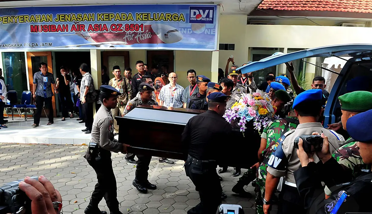 Tim DVI Polda Jawa Timur melakukan penyerahan jenazah korban pesawat AirAsia QZ8501 di RS Bhayangkara, Surabaya, Jumat (2/1/2015). Tampak, beberapa personil TNI-Polri memasukkan peti jenazah korban pesawat AirAsia QZ8501. (Liputan6.com/Johan Tallo)