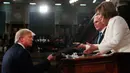 Presiden Amerika Serikat Donald Trump (kiri) menyerahkan naskah pidato kenegaraannya kepada Ketua DPR Nancy Pelosi dalam Kongres di Capitol Hill, Washington, Selasa (4/2/2020). Trump menyampaikan pidatonya sehari jelang keputusan persidangan pemakzulannya di level Senat AS. (Leah Millis/Pool via AP)