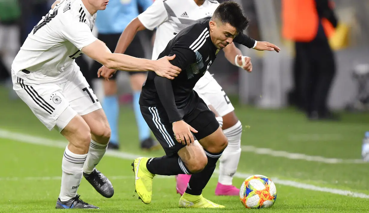 Pemain Argentina, Marcos Acuna, berusaha melewati pemain Jerman pada laga persahabatan di Stadion Signal Iduna Park, Rabu (9/10). Kedua tim bermain imbang 2-2. (AP/Martin Meissner)