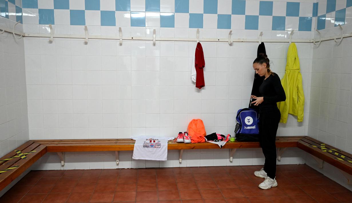 Pemain Spanyol Club Balonmano Albacete, Mireia Rodriguez bersiap-siap di ruang ganti pribadinya sebelum pertandingan pertamanya melawan Cabanillas di Albacete pada 6 November 2021. Mireia Rodriguez adalah wanita pertama yang bergabung dengan tim bola tangan pria profesional. (GABRIEL BOUYS / AFP)