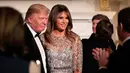 Presiden AS, Donald Trump dan Melania Trump berbincang pada acara jamuan makan malam White House Historical Association, Jumat (15/9). Melania berbalut gaun dengan manik-manik silver yang harganya mencapai Rp106 juta. (AP Photo/Manuel Balce Ceneta)