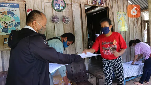 Guru SMPN 16 Sigi memberikan lembaran soal pelajaran ke Nolin (15 th).
