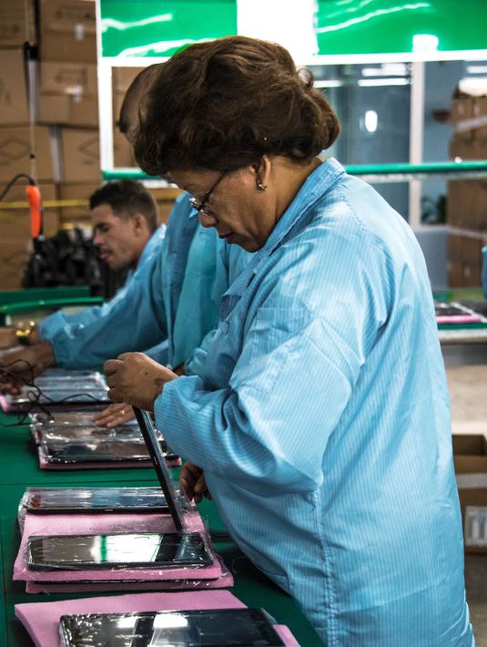 Teknisi wanita menyelesaikan proses perakitan tablet PC berteknologi Haier China di Gedeme, Havana, Kuba (15/5). Kuba-China menjalani kemitraan dalam bidang industri elektronik komputer. (AFP Photo/Adalberto Roque)