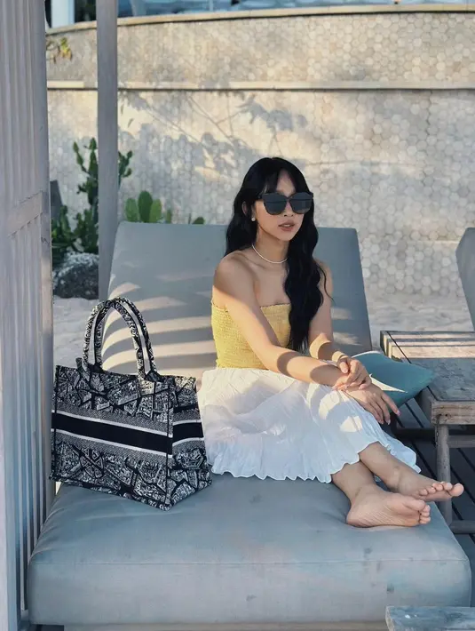 Di musim panas, Dita tampil cantik mengenakan bandeau top warna kuning, rok a-line putih, dan tote bag. [@secretnumber.official]