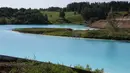 Pemandangan tempat pembuangan abu dari pabrik batubara lokal yang sering disebut 'Maladewa di Siberia' di Danau Novosibirsk, Rusia, Kamis (11/7/2019). Warna biru terang danau itu berasal dari garam kalsium dan oksida logam yang tercampur di dalamnya. (Rostislav NETISOV/AFP)