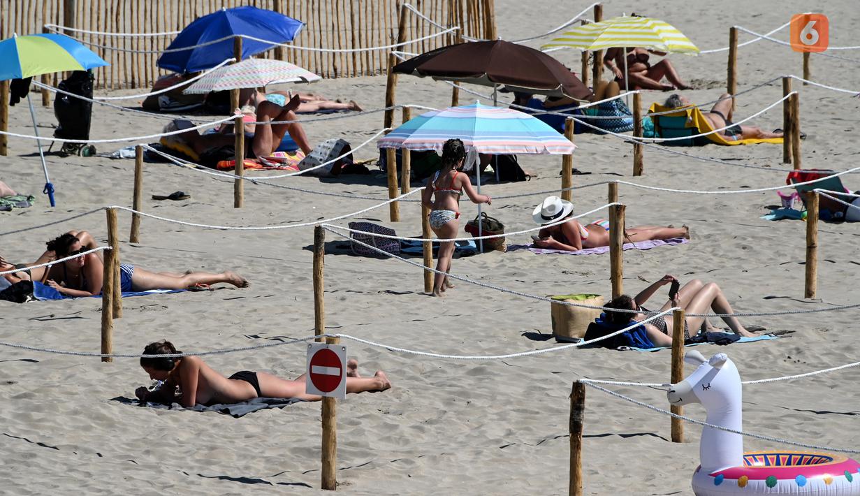Orang-orang berjemur menikmati matahari di Sunset Beach dengan area terpisah untuk mematuhi jaga jarak di La Grande-Motte, Prancis, Selasa (26/5/2020). Metode kini tengah dalam masa uji coba hingga setidaknya 2 Juni untuk dievaluasi efektivitasnya oleh otoritas. (Pascal GUYOT/AFP)