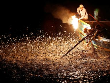 Nelayan menggunakan api sebagai umpan saat menarik ikan di perairan New Taipei City, Taiwan, (19/6). Metode tradisional ini merupakan cara nelayan taiwan untuk mendapatkan ikan tanpa menggunakan bom yang dapat merusak ekosistem laut. (REUTERS/Tyrone Siu)