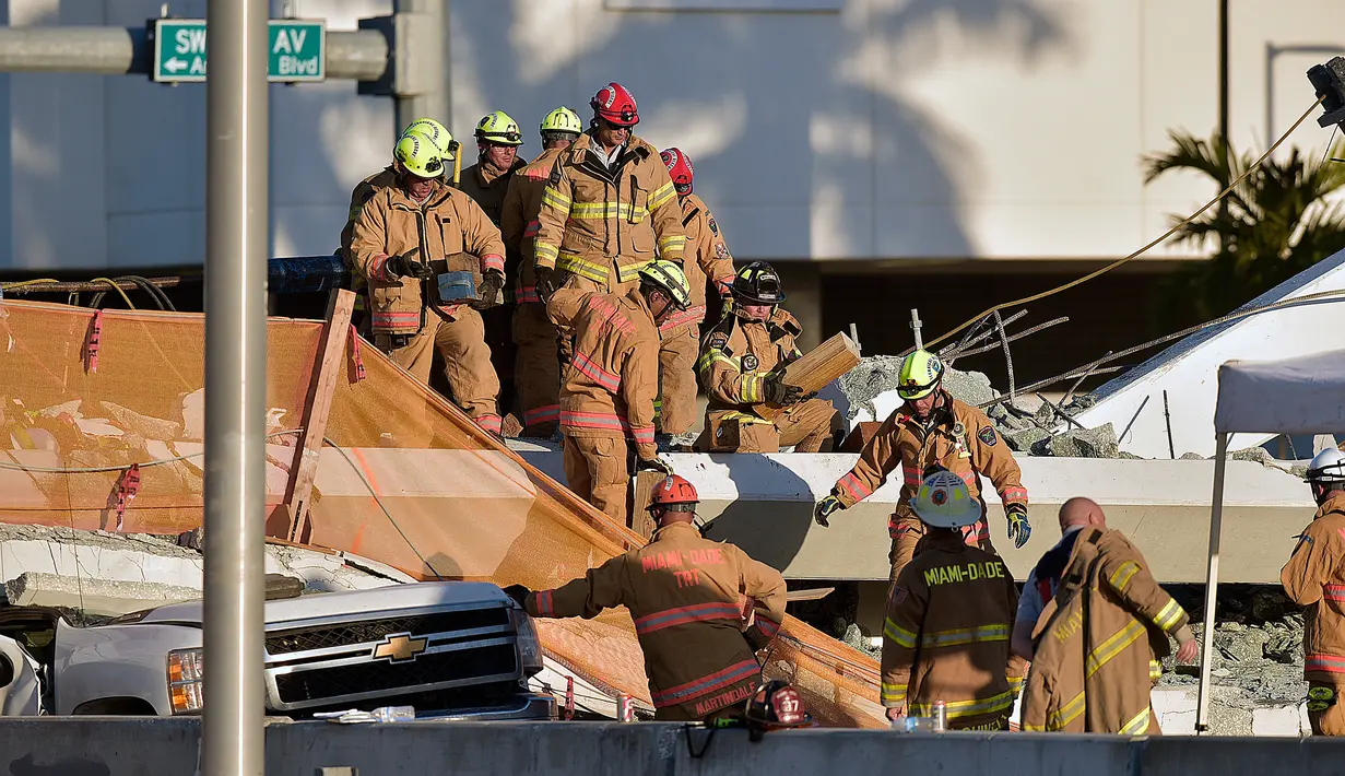 Petugas pemadam kebakaran Miami-Dade Fire Rescue mengevakuasi korban jembatan pejalan kaki yang runtuh di Miami, Florida (15/3). (Michael Laughlin / South Florida Sun-Sentinel via AP)