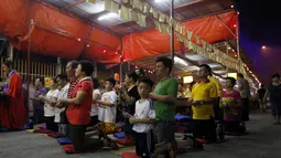 Menurut Tao dan keyakinan Budha, bulan ketujuh dalam kalender Imlek Tiongkok dikenal sebagai festival Hungry Ghost. Beberapa warga keturunan Tiongkok berdoa saat festival Hungry Ghost, (3/8/2014). (REUTERS/Olivia Harris)