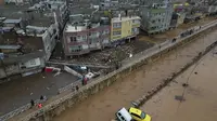 Kendaraan dan puing-puing berserakan akibat banjir yang dipicu hujan deras di Sanliurfa, Turki, pada Rabu (15/3/2023). Banjir akibat hujan deras melanda dua provinsi yang porak poranda akibat gempa bulan lalu, menewaskan sedikitnya 14 orang. (Dok. Hakan Akgun/DIA via AP)