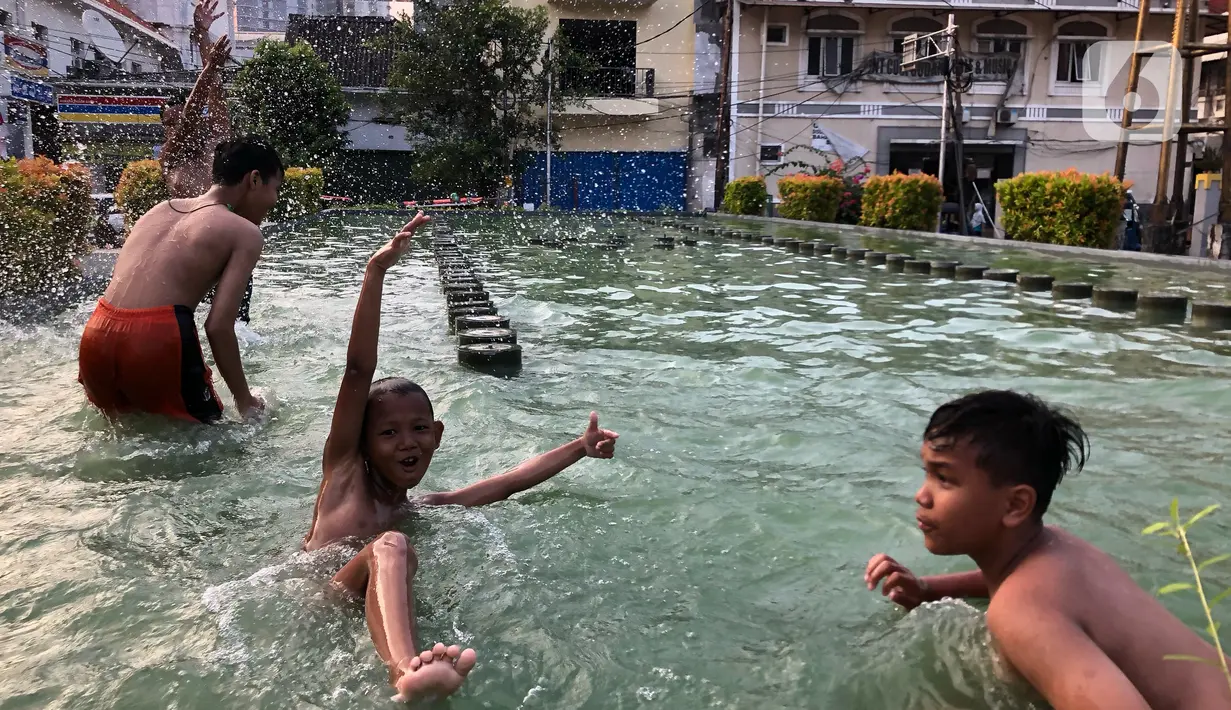 Anak-anak berenang di kolam penghias taman Pasar Baru di Jakarta, Rabu (2/9/2020). Meskipun terdapat larangan, namun sejumlah anak tetap nekat berenang di kolam tersebut sehingga mengganggu ketertiban umum. (Liputan6.com/Immanuel Antonius)