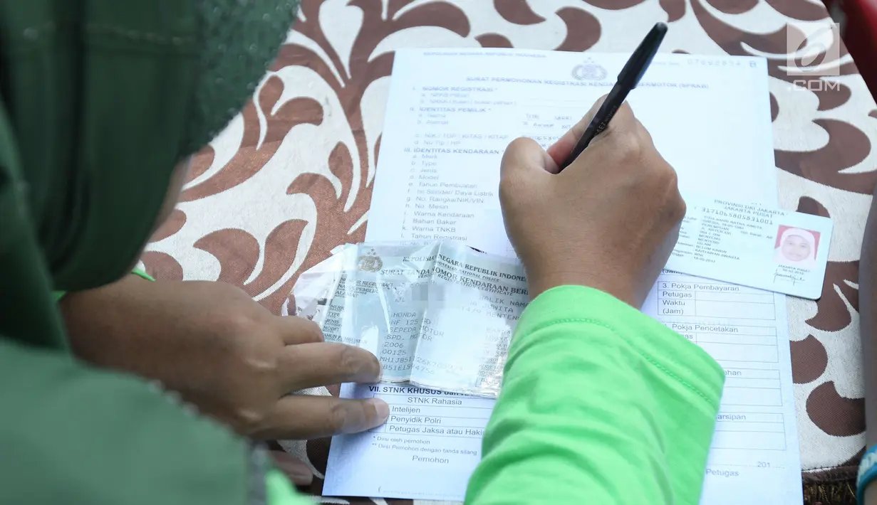 Warga mengisi formulir untuk membayar pajak kendaraan bermotor di gerai Samsat Keliling Car Free Day, Jakarta, Minggu (21/10). Agar bisa membayar pajak ini cukup menggunakan STNK dengan nama yang tertera harus sesuai KTP. (Liputan6.com/Angga Yuniar)