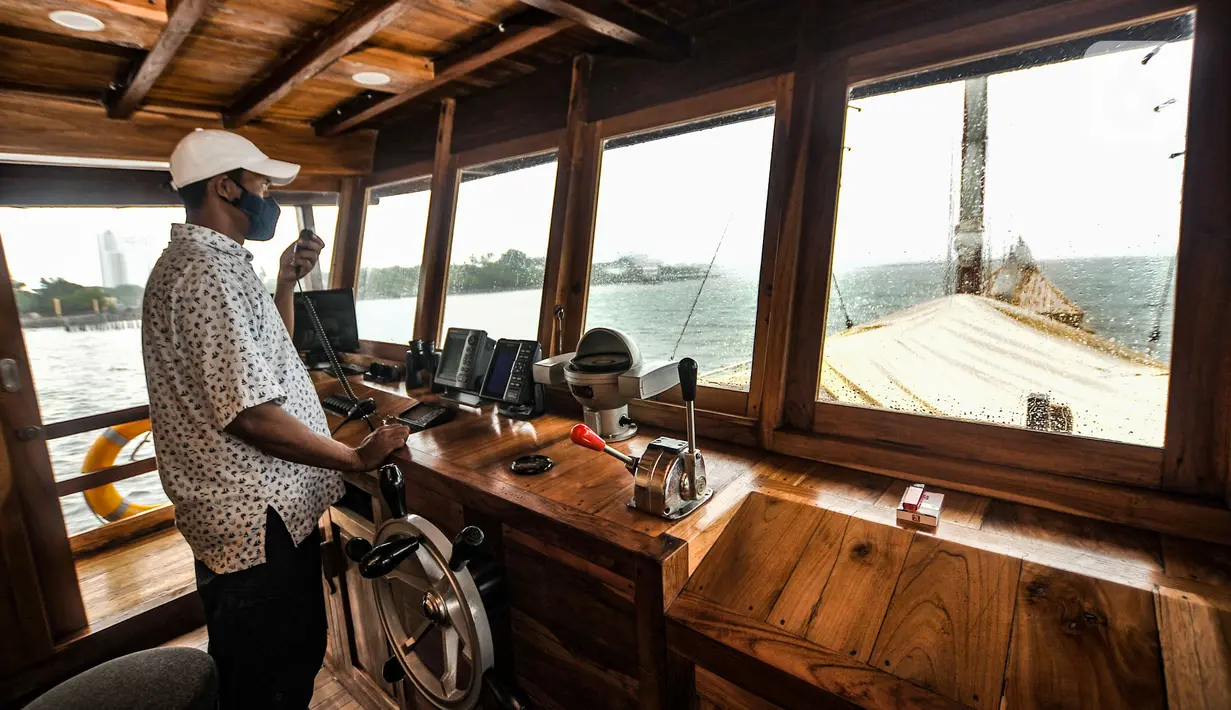 Nakhoda saat mengoperasi kemudi Kapal Augustine Phinisi di kawasan Ancol, Jakarta, Selasa (23/3/2021). Augustine Phinisi dibuat sebagai alternatif liburan yang dihadirkan di kawasan Taman Impian Jaya Ancol. (merdeka.com/Iqbal S. Nugroho)