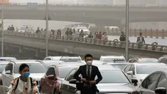 Warga mengenakan masker melewati kendaraan yang terjebak kemacetan saat badai debu di jalanan Beijing, Kamis (4/5). Badai debu menerjang utara China dan Beijing, serta membuat otoritas membatalkan puluhan penerbangan. (AP Photo/Andy Wong)