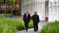 Momen ketika Presiden AS Donald Trump (kiri) dengan Pemimpin Korea Utara Kim Jong-un berjalan di taman Hotel Capella, Pulau Sentosa, Singapura, Selasa (12/6). Trump dan Kim optimis bahwa KTT akan sukses. (Anthony Wallace/Pool/AFP)