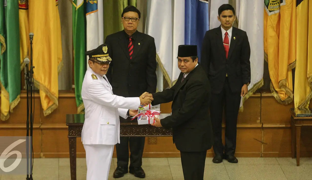 Mendagri Tjahjo Kumolo (tengah) menyaksikan serah terima berkas jabatan Penjabat Gubernur Jambi Irman (kiri) dengan Gubernur Jambi periode 2010-2015 Hasan Basri Agus di Kemendagri, Jakarta, Rabu (5/8/2015). (Liputan6.com/Faizal Fanani)