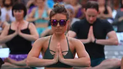 Seorang wanita melakukan gerakan yoga di tengah jalan Times Square, New York pada 'Summer Solstice' atau hari dengan siang terpanjang di musim panas, Rabu (21/6). Acara itu menandai Hari Yoga Internasional yang jatuh pada 21 Juni. (TIMOTHY A. CLARY/AFP)