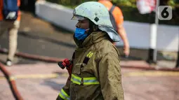 Petugas pemadam kebakaran usai melakukan pendingan di Gedung Kejaksaan Agung RI yang terbakar, Minggu (23/8/2020). Kebakaran di gedung Kejaksaan Agung pada Sabtu (22/8) malam akhirnya padam dan kini bangunan tersebut menyisakan bagian hitam legam. (Liputan6.com/Faizal Fanani)