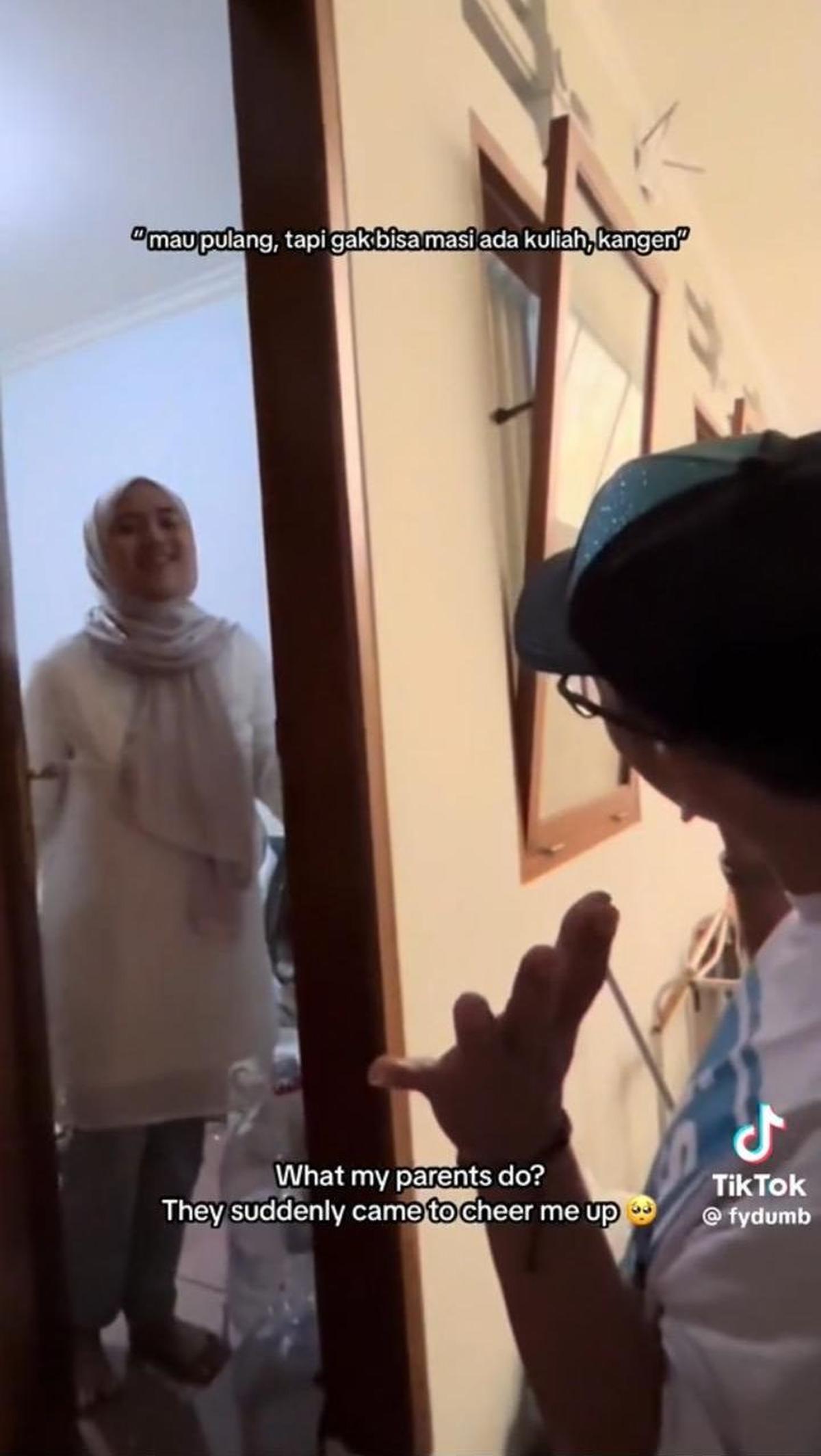 Tak lama, anaknya tampak membuka pintu dari dalam. Saat pintu terbuka, anak ini tampak kaget melihat ayahnya ada di depan kosannya.
