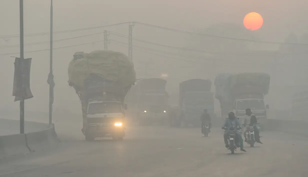 Pengendara kendaraan melintas di tengah kondisi kabut asap di Lahore, Pakistan, Senin (8/11/2021). Lahore menjadi salah satu kota paling tercemar di dunia. (Arif ALI/AFP)