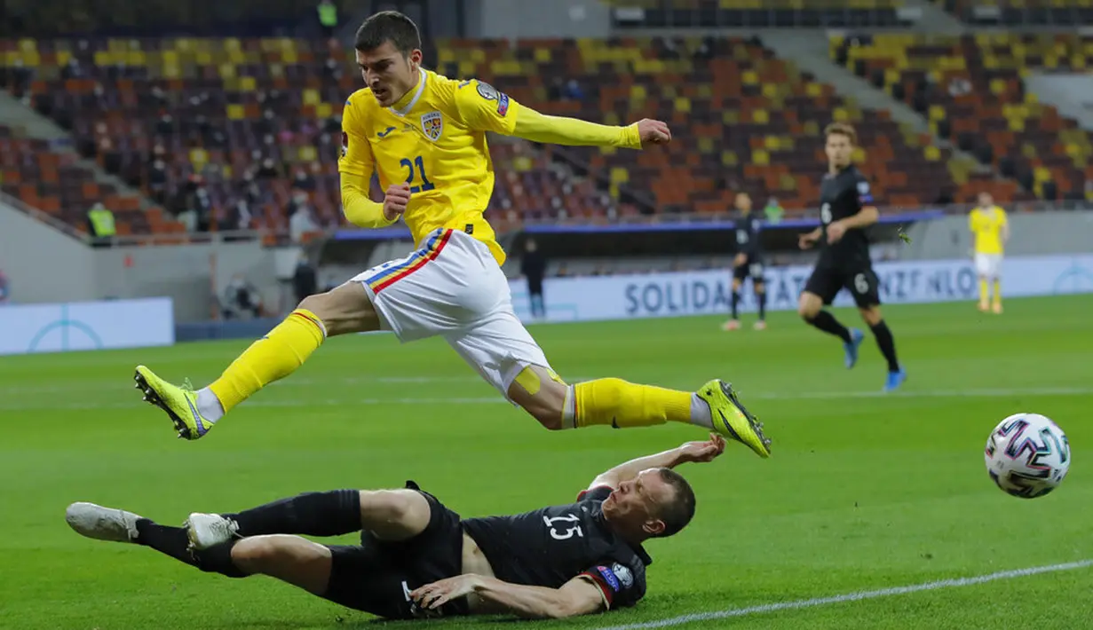 Pemain Rumania Valentin Mihaila (atas) melompati pemain Jerman Lukas Klostermann saat memperebutkan bola pada pertandingan Grup J kualifikasi Piala Dunia 2022 di Stadion National Arena, Bucharest, Rumania, Minggu (28/3/2021). Jerman menang 1-0 atas Rumania. (AP Photo/Vadim Ghirda)