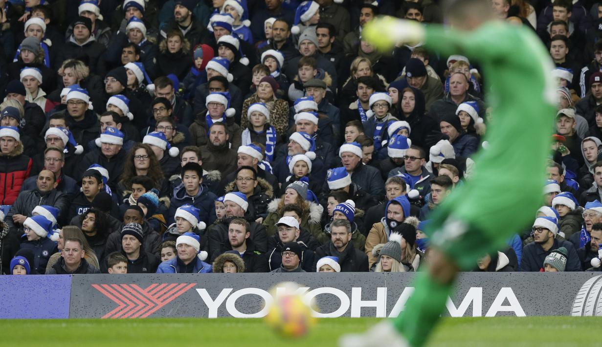 Fans Chelsea menggunakan topi Santa Klaus menyambut Natal saat laga timnya melawan Southampton pada laga Premier League di Stamford Bridge, London, (16/12/2017). Chelsea menang 1-0. (AP/Tim Ireland)